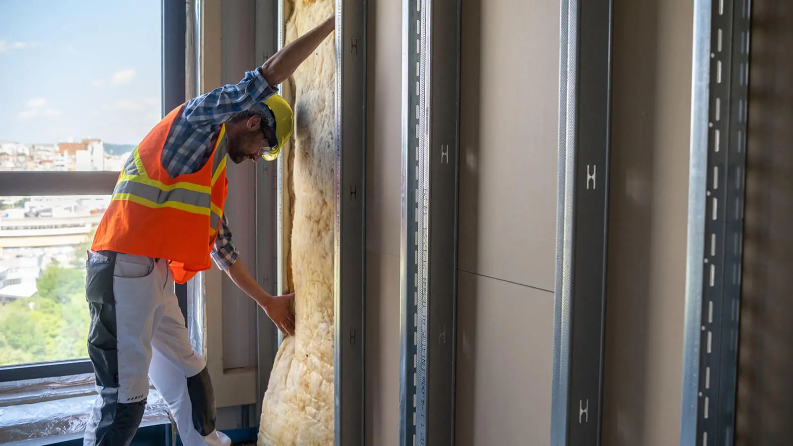 Worker fitting insulation in building