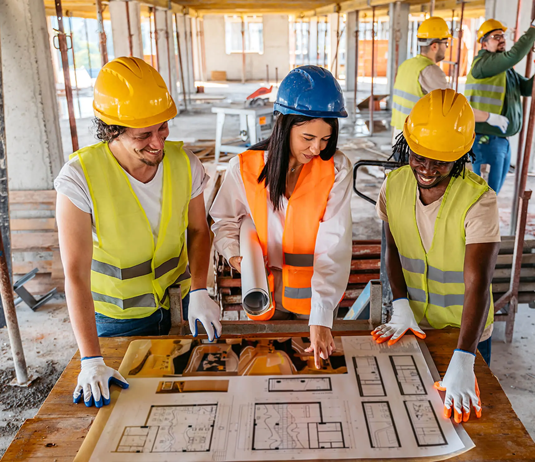 Workers discussing architectural blueprint